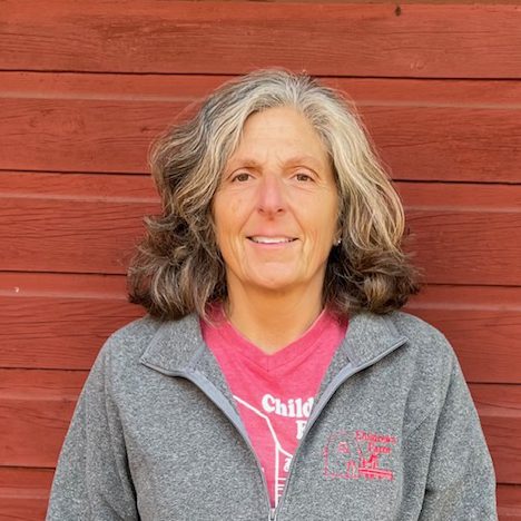 photo of Jeanne Leppicello standing in front of red barn wall